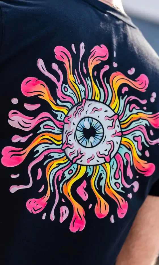 Detailed full-colour illustration of an eyeball and swirling colours, DTF printed on a black t-shirt